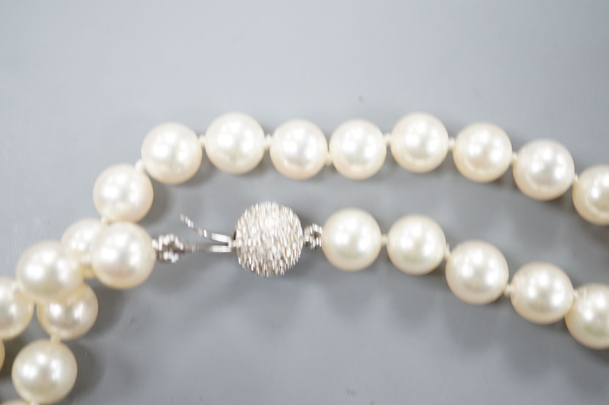 A modern single strand cultured pearl necklace, with diamond chip set spherical clasp, 72cm.